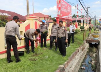 TANAM POHON: Personel Polresta Deliserdang menanam pohon di depan Mapolresta, Senin (28/8/2023). (Foto Dok/ Polresta DS)
