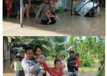 Tampak Aiptu Ponirin menolong dan memapah seorang nenek dan anak kecil dari genangan air ke tempat yang tidak tergenang