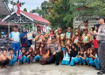 FOTO BERSAMA: Usai penyerahan bantuan buku, Kapolsek Tanjungberingin, AKP Tobat Sihombing foto bersama bersama para pelajar SD Negeri 106217 Amaliun Dusun VI Desa Pekan Tanjungberingin, Sabtu (2/9/2023). (Foto Dok/AKP Tobat Sihombing)