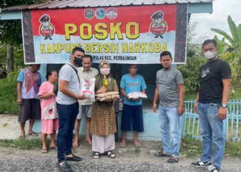 POSKO KBN : Kanit I Satnarkoba Polres Sergai, Ipda Anggiat Sidabutar bersama personel memberikan bantuan kepada warga saat menginisiasi Pisko Kampung Besih Narkoba di Dusun I Desa Bengkel, Kecamatan Perbaungan, Sabtu (2/9/2023). (Foto Dok/Polres Sergai)