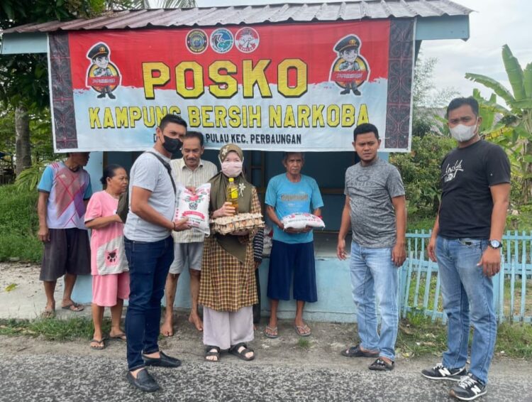 POSKO KBN : Kanit I Satnarkoba Polres Sergai, Ipda Anggiat Sidabutar bersama personel memberikan bantuan kepada warga saat menginisiasi Pisko Kampung Besih Narkoba di Dusun I Desa Bengkel, Kecamatan Perbaungan, Sabtu (2/9/2023). (Foto Dok/Polres Sergai)