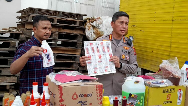 TUNJUK BARANG BUKTI: Kapolrestabes Medan Kombes Pol Valentino Alfa Tatareda SH SIK didampingi Kasat Reskrim Kompol Teuku Fathir Mustafa menunjukkan barang bukti bahan-bahan pembuatan oli palsu, Sabtu (2/9/2023).(Foto Dok/Polrestabes)