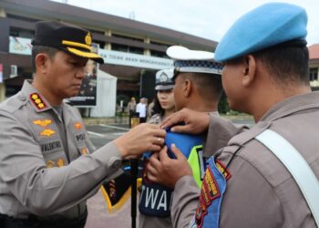 SEMATKAN PITA: Kapolrestabes Medan Kombes Pol Valentino Alfa Tatareda SH SIK menyematkan pita kepada personel yang terlibat dalam Operasi Kewilayahan Zebra Toba 2023, di lapangan apel Mapolrestabes, Senin (4/9/2023).(Foto Dok/Polrestabes)
