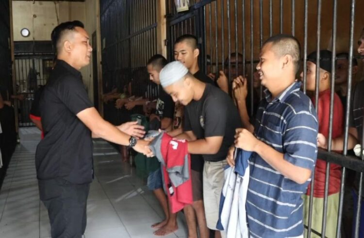 MOTIVASI : kasi Humas Polres Sergai, Ipda Brumen G Sihotang memverikan motivasi dan penghiburan, serta memberikan kaos baru kepada para tahanan yang ada di RTP Polres Sergai, Kamis (7/9/2023). (Foto Dok/Sie Humas)