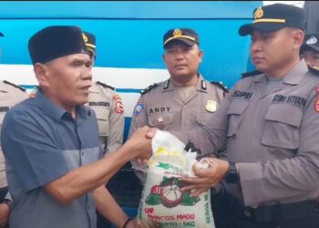 BERI BANTUAN: Personel Polsek Delitua memberikan bantuan beras dan air bersih ke Sekolah Pesantren Panti Asuhan Alwasliyah, Jumat (8/9/2023).(Foto Dok/ Ist Polsek Delitua)