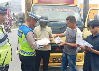 BAGI BROSUR : Personel Satlantas Polres membagikan brosur imbauan tertib belalulintas kepada pengendara saat menggelar Ops Zebra Toba di Jalinsum Medan-Tebingtinggi, Desa Seirampah, Kecamatan Seirampah, Senin (11/9/2023). (Foto Dok/Sie Humas Polres Sergai)