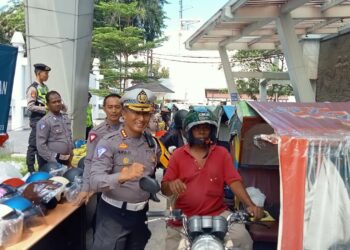 BAGI HELM: Direktur Lantas Polda Sumut, Kombes Pol Muji Ediyanto membagikan helm SNI ke abang betor, Senin (11/9/2023). (Foto Dok/ Polda Sumut)