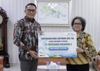TERIMA SHT : Direktur PTPN2 Irwan Perangin-angin secara simbolis menyerahkan SHT kepada pensiunan Ria Irene Sitepu, baru-baru ini. (Foto. Dok/PTPN2).