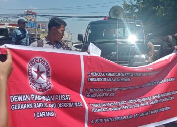 BENTANGKAN SPANDUK: Sejumlah mahasiswa dari DPP GARANSI bentangkan spanduk saat unras di Mapolda Sumut, Selasa (19/9/2023). (Foto Dok/ T77)