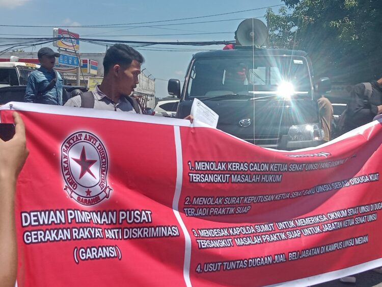BENTANGKAN SPANDUK: Sejumlah mahasiswa dari DPP GARANSI bentangkan spanduk saat unras di Mapolda Sumut, Selasa (19/9/2023). (Foto Dok/ T77)