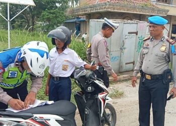 TINDAK : Personel Satlantas Polres Sergai disaksikan Kasi Propam AKP Adi Santika menindak pelanggar tertib lalulintas saat Ops Zebra Toba berlangsung. (Foto Dok/Humas Polres Sergai)