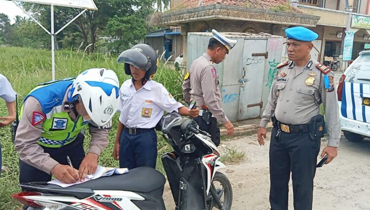 TINDAK : Personel Satlantas Polres Sergai disaksikan Kasi Propam AKP Adi Santika menindak pelanggar tertib lalulintas saat Ops Zebra Toba berlangsung. (Foto Dok/Humas Polres Sergai)