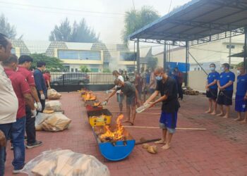 TERSANGKA BAKAR GANJA: Para tersangka narkoba membakar barang bukti ganja di kantor BNNP Sumut, Jumat (22/9/2023).(Foto Dok/BNN)