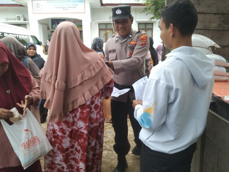Personel Subsektor Nisam Antara mengawal proses penyaluran Beras BP-CBP Tahap II Tahun 2023 kepada masyarakat di Kecamatan Nisam Antara, Aceh Utara, wilayah hukum Polres Lhokseumawe, Selasa (26/9/2023).