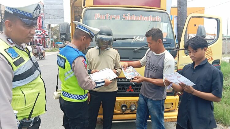 BAGI BROSUR : Personel Satlantas Polres membagikan brosur imbauan tertib belalulintas kepada pengendara saat menggelar Ops Zebra Toba di Jalinsum Medan-Tebingtinggi, Desa Seirampah, Kecamatan Seirampah, Senin (11/9/2023). (Foto Dok/Sie Humas Polres Sergai)