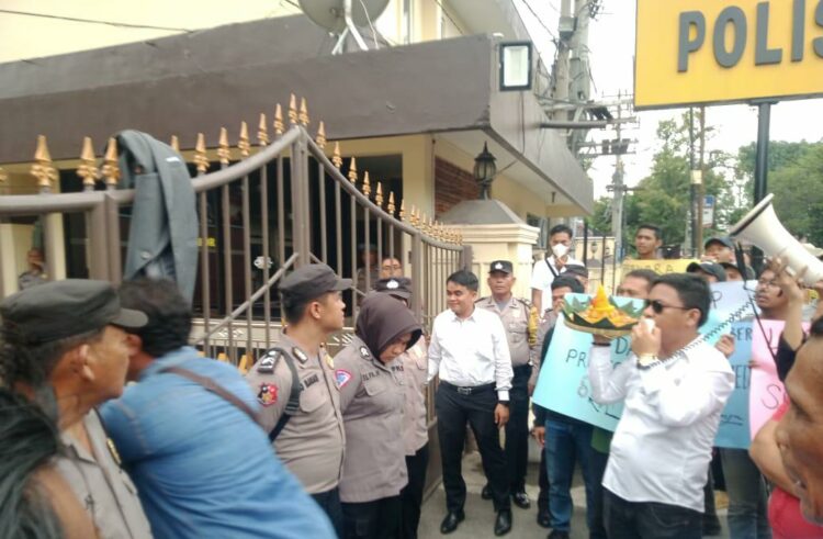 NASI TUMPENG: Aliansi Masyarakat Cerdas menghadiahi nasi tumpeng kepada penyidik saat melakukan unjuk rasa di depan Polrestabes Medan, Kamis (12/10/2023). (Foto Dok/T77)