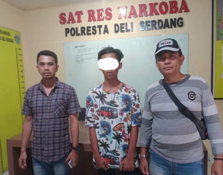 DIAPIT PERSONEL : Tersangka pengedar sabu AGS diapit Personel, saat diserahkan ke Satres Narkoba Polresta Deliserdang, Jumat (27/10/2023) di Lubukpakam. (Foto.Dok/Polsek Batangkuis)