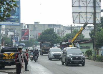 KAWAL : Personel Polres Sergai mengawal dan melakukan pengamanan penertiban APS para Caleg oleh tim Bawaslu Sergai di Jalan Lintas Medan-Tebingtinggi Kecamatan Perbaungan, Rabu (15/11/2023). (Foto Dok/Humas Polres Sergai).