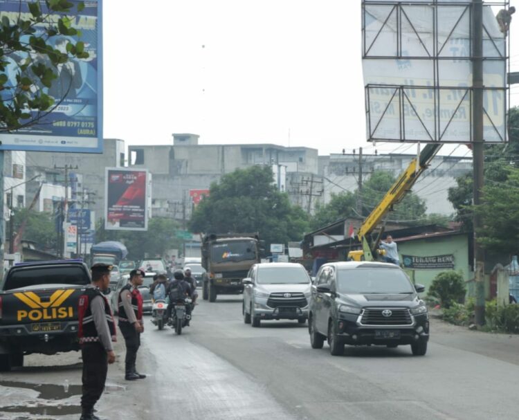 KAWAL : Personel Polres Sergai mengawal dan melakukan pengamanan penertiban APS para Caleg oleh tim Bawaslu Sergai di Jalan Lintas Medan-Tebingtinggi Kecamatan Perbaungan, Rabu (15/11/2023). (Foto Dok/Humas Polres Sergai).