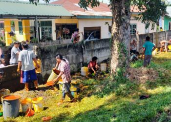KUMPULKAN CPO : Puluhan massa mengumpulkan CPO yang tumpah di bahu jalan tol Belmera Medan Labuhan setelah mobil tangki dan truk kontainer tabrakan, Senin (27/11/2023).(Foto Dok/P)