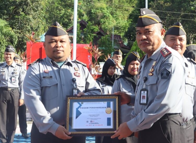 Kepala Lembaga Pemasyarakatan (Lapas) Kelas IIB Bitung Kanwil Kemenkumham Sulawesi Utara, Syukron Hamdani, menyerahkan piagam penghargaan kepada pegawai saat pelaksanaan apel pagi. Selasa (28/11/23).
