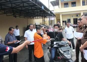 REKONSTRUKSI : ZE alias Ai (27) terduga pelaku pembunuhan terhadap pamannya Poniran (56), memeragakan adegan pada pada rekonstruksi yang digelar Satreskrim Polres Sergai disaksikan penyidik dan tim jaksa dari Kejari Sergai serta penasehat hukum teesangka, Rabu (6/12/2023). (Foto Dok/ Polres Sergai)
