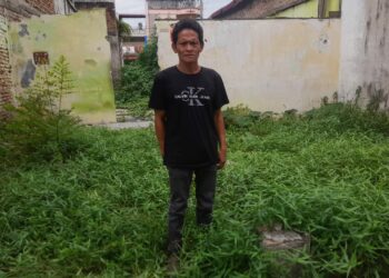 AYAH KORBAN PEMBAKARAN: Ribut Hartono, ayah dari Deni yang menjadi korban pembakaran hingga tewas karena dituduh mencuri handphone tanpa adanya bukti, saat berkunjung ke bekas rumah lamanya yang sudah rubuh Jalan Perkutut Raya Perumnas Mandala, Kecamatan Percut Sei Tuan, Deliserdang, Senin (11/12/2023).(Foto Dok/Warga)