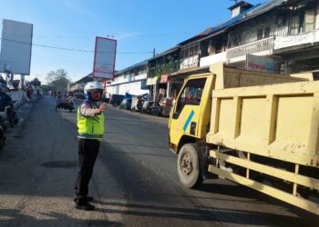 ATUR LALIN: Kanit Lantas Polsek Pancurbatu Iptu M Rizal sedang mengatur lalulintas di Jalan Jamin Ginting, Kecamatan Pancurbatu, atau tepatnya di kawasan Pajak Pancurbatu, Senin (11/12/2023). (Foto Dok/A Sinuhaji)