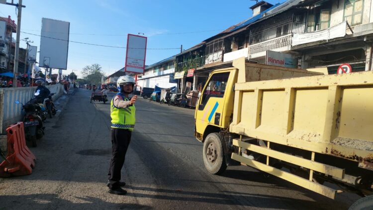 ATUR LALIN: Kanit Lantas Polsek Pancurbatu Iptu M Rizal sedang mengatur lalulintas di Jalan Jamin Ginting, Kecamatan Pancurbatu, atau tepatnya di kawasan Pajak Pancurbatu, Senin (11/12/2023). (Foto Dok/A Sinuhaji)