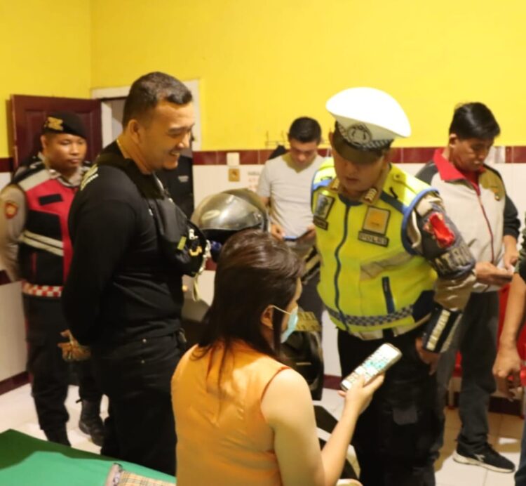 PERIKSA : Personel Polres Sergai memeriksa identitas dan barang-barang pengunjung saat merazia tempat penginapan di Seibamban, Selasa (19/12/2023) malam. (Foto Dok/Humas Polres)