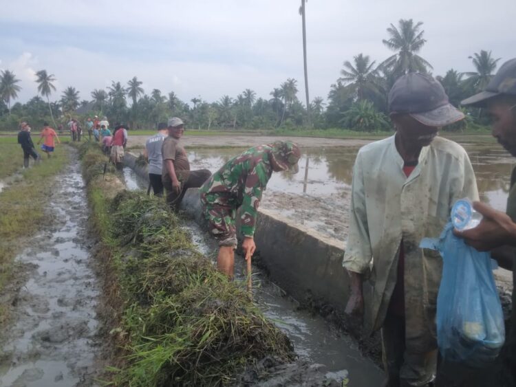 Babinsa Koramil 07/Mrm Kodim 0103/Aceh Utara Serda Rahmat Syahran bersama warga membersihkan saluran irigasi pengairan menuju arah kesawah di Desa Pulo Bluek, Kecamatan Meurah Mulia, Kabupaten Aceh Utara, Sabtu (06/01/2024).