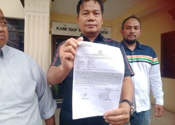 TUNJUKKAN LP: Pengacara Rizkika Azizah yang juga koordinator THN AMIN Sumut, Yance Aswin SH menunjukkan surat tanda lapor pegawai Dishub Kota Medan di depan Kantor SPKT Polrestabes Medan, Sabtu (7/1/2024) (Foto Dok/Tim)