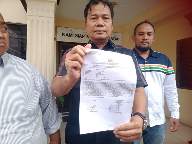 TUNJUKKAN LP: Pengacara Rizkika Azizah yang juga koordinator THN AMIN Sumut, Yance Aswin SH menunjukkan surat tanda lapor pegawai Dishub Kota Medan di depan Kantor SPKT Polrestabes Medan, Sabtu (7/1/2024) (Foto Dok/Tim)