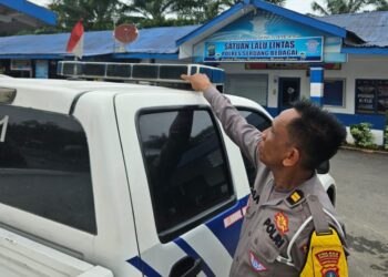 TUNJUKKAN : Kanit Turjawali Satlantas Polres Iptu Iman M menunjukkan lampu rotator kendaraan dinas yang telah ditutup dengan sticker kaca film, Sabtu (6/1/2024). (Foto Dok/Humas Polres)