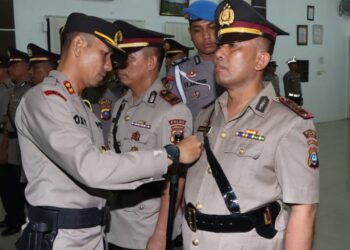 SEMATKAN :Kapolres Sergai, AKBP Oxy Yudha Pratesta menyematkan tanda jabatan kepada AKP Sunipan Guru Singa selaku Kapolsek Perbaungan yang baru saat memimpin.Sertijab Kasatres Narkoba,.Kasat Binmas dan empat Kapolsek jajaran,.Rabu.(10/1/2024). (Foto Dok/Humas Polres Sergai)