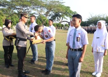 SERAHKAN HADIAH : Kapolres Sergai, AKBP Oxy Yudha Pratesta menyerahkan hadiah kepada pelajar pemenang lomba fotografi Safety Riding dan Bahaya Narkoba, Senin (5/2/2024). (Foto Dok/Humas Polres)