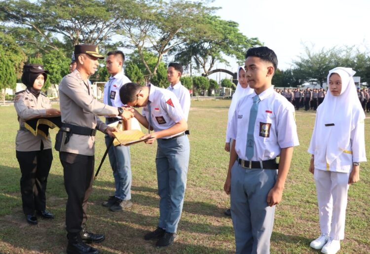 SERAHKAN HADIAH : Kapolres Sergai, AKBP Oxy Yudha Pratesta menyerahkan hadiah kepada pelajar pemenang lomba fotografi Safety Riding dan Bahaya Narkoba, Senin (5/2/2024). (Foto Dok/Humas Polres)