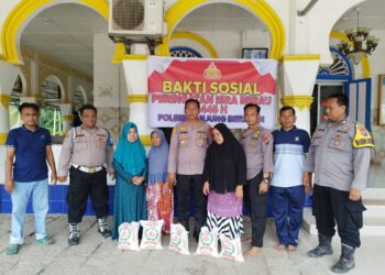 DIABADIKAN : Kapolsek Tanjungberingin AKP Tobat Sihombing didampingi Kanit Samapta Iptu Supriadi dan personel diabadikan bersama warga penerima bantuan, Jumat (9/2/2024). (Foto Dok/Polsek Tanjungberingin).