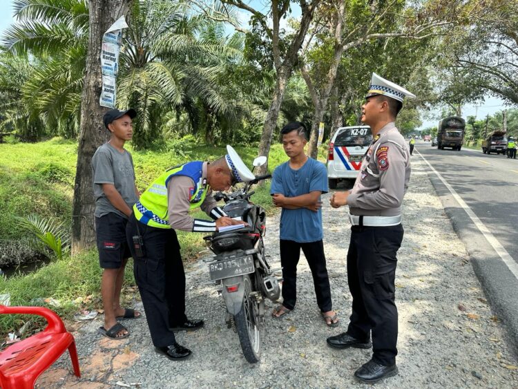 TINDAKAN : Personel Satlantas Polres Sergai memberikan tindakan kepada pengendara pelanggar lalulintas, Jumat (9/2/2024). (Foto Dok/Humas Polres)