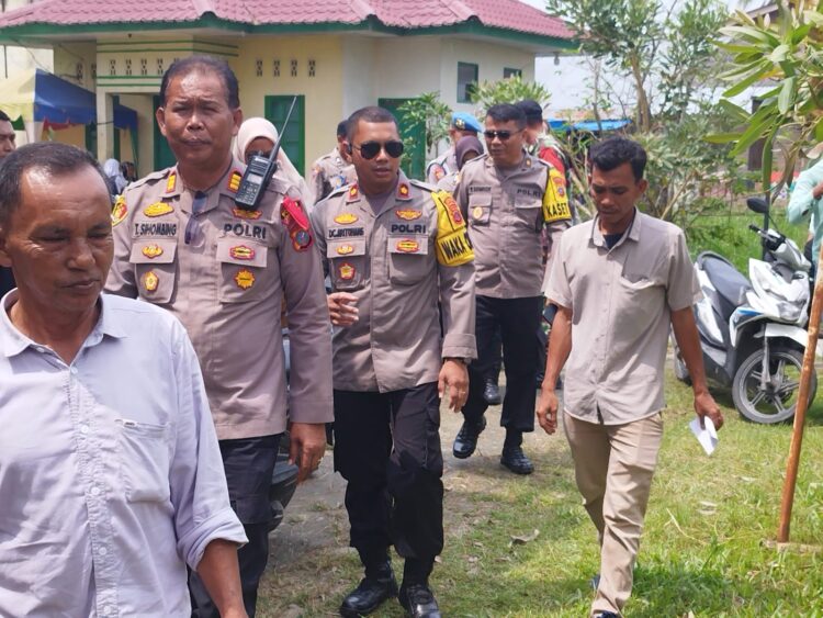 PANTAU : Wakapolres Sergai, Kompol Damos C Aritonang bersama para PJU Polres Sergai didampingi Kapolsek Tanjungberingin, AKP Tobat Sihombing memantau rekapitulasi penghitungan suara hasil Pemilu 2024 di Kantor PPK Tanjungberingin, Senin (19/2/2024). (Foto Dok/Humas Polres)