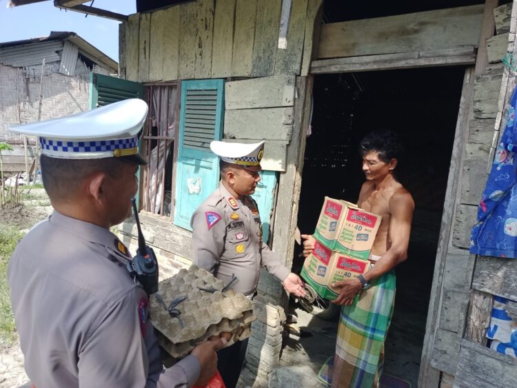 SERAHKAN BANTUAN : Kasat Lantas Polres Sergai, AKP Andita Sitepu didampungi Kbo Iptu W Saragih menyerahkan paket bantuan ke warga kurang mampu pada kegiaran Baksos Jumat Berkah, Jumat (23/2/2024). (Foto Dok/Humas Polres)