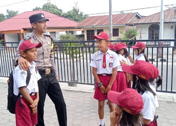 Bripka Agus Sutopo, Personil Bhabinkamtibmas dari Polsek Simanindo, berinisiatif menyapa para pelajar di SD Negeri 15 Ambarita Kecamatan Simanindo Kabupaten Samosir.