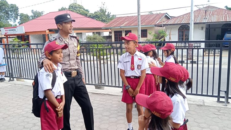 Bripka Agus Sutopo, Personil Bhabinkamtibmas dari Polsek Simanindo, berinisiatif menyapa para pelajar di SD Negeri 15 Ambarita Kecamatan Simanindo Kabupaten Samosir.