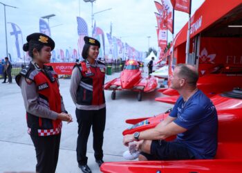 BERDIALOG: Personel yang fasih berbahasa Inggris berdialog dengan wisatawan yang akan menyaksikan F1 Powerboat. (Foto Dok/ Polda Sumut)