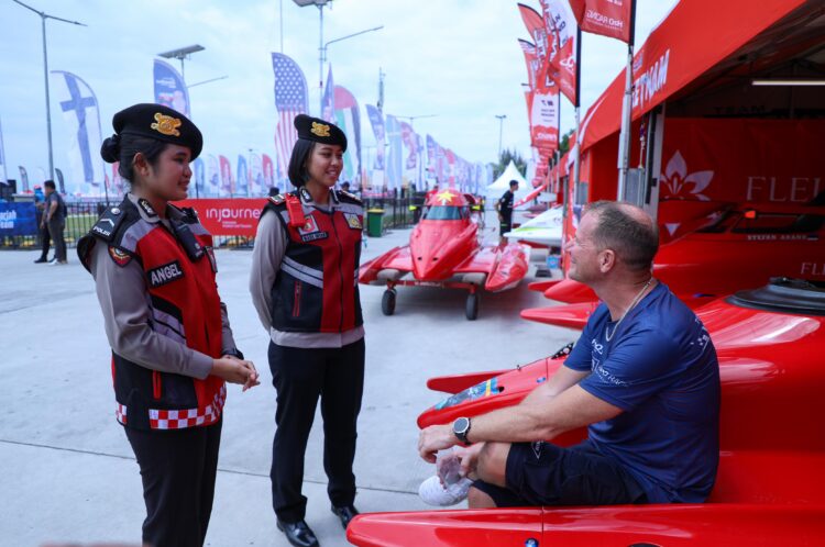 BERDIALOG: Personel yang fasih berbahasa Inggris berdialog dengan wisatawan yang akan menyaksikan F1 Powerboat. (Foto Dok/ Polda Sumut)
