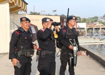 MEMANTAU: Personel Satuan Brimob Polda Sumut memantau keberadaan drone liar yang tidak memiliki izin terbang di sekitar venue F1 Powerboat, Sabtu (2/3/2024). (Foto Dok/ Polda Sumut)
