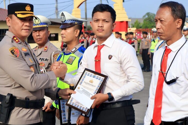 BERI PENGHARGAAN: Kapolres Pelabuhan Belawan AKBP Janton Silaban memberikan penghargaan kepada salah seorang personel berprestasj, Rabu (6/3/2024).(Foto Dok/Polres Belawan)