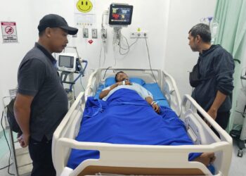 CEK KORBAN : Kanit Reskrim Polsek Perbaungan, Ipda Raja K Haloho (kiri) bersama personel Unit Reskrim saat mencek kondisi Saddam Syahputra (33), korban penganiayaan yang sedang menjalani perawatan di RS Grand Medistra Lubuk Pakam, Minggu (10/3/2024). (Humas Polres)