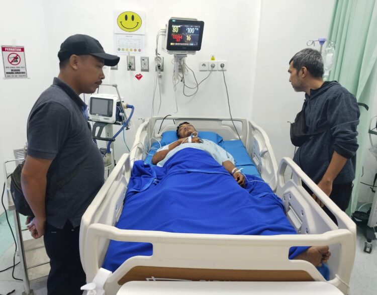 CEK KORBAN : Kanit Reskrim Polsek Perbaungan, Ipda Raja K Haloho (kiri) bersama personel Unit Reskrim saat mencek kondisi Saddam Syahputra (33), korban penganiayaan yang sedang menjalani perawatan di RS Grand Medistra Lubuk Pakam, Minggu (10/3/2024). (Humas Polres)