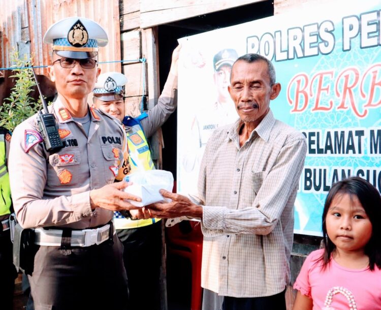 BAGI TAKJIL: Kasat Lantas Polres Pelabuhan Belawan membagikan takjil kepada salah seorang warga di Belawan, Sabtu (16/3/2024).(Foto Dok/Polres Belawan)